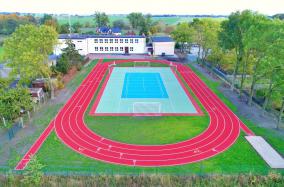 Boisko ze sztuczną nawierzchnią i bieżnia lekkoatletyczna przy szkole w Różannie