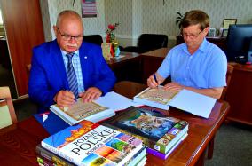 Najlepsi uczniowie wyróżnieni_fot_Wójt Adam Licznerski i przewodniczący Komisji Oświaty Adam Czarnecki podpisują pamiątkowe dyplomy dla uczniów